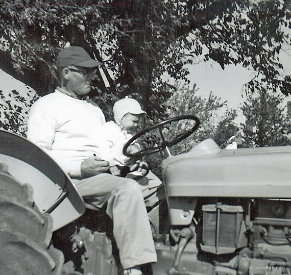 man and baby on tractor